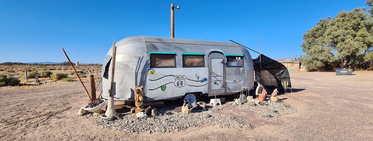 An Airstream trailer outside the Bagdad Cafe on old Route 66 in Newberry Springs, California, under a clear desert sky